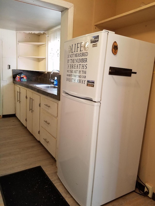 kitchen featuring decorative backsplash, sink, white refrigerator, and light hardwood / wood-style floors