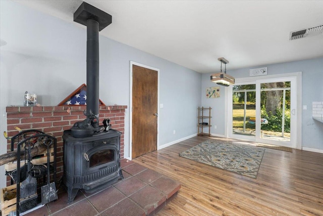 living room featuring dark wood-type flooring and a wood stove