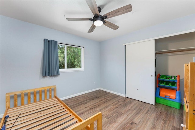 bedroom with a closet, wood-type flooring, and ceiling fan