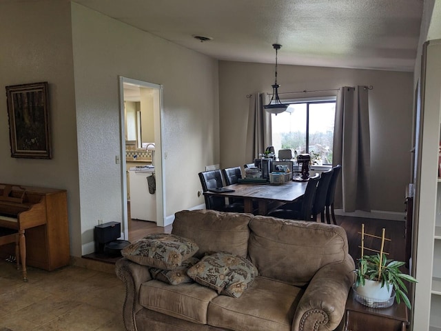 living room with a textured ceiling and vaulted ceiling