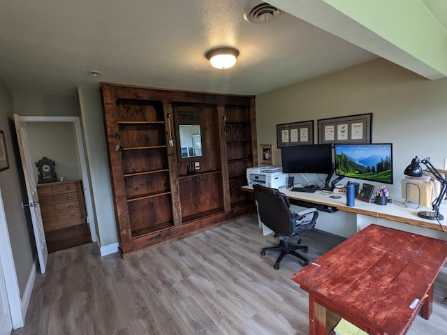 office area featuring a textured ceiling and light hardwood / wood-style floors