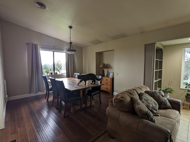 dining area with vaulted ceiling and dark hardwood / wood-style floors