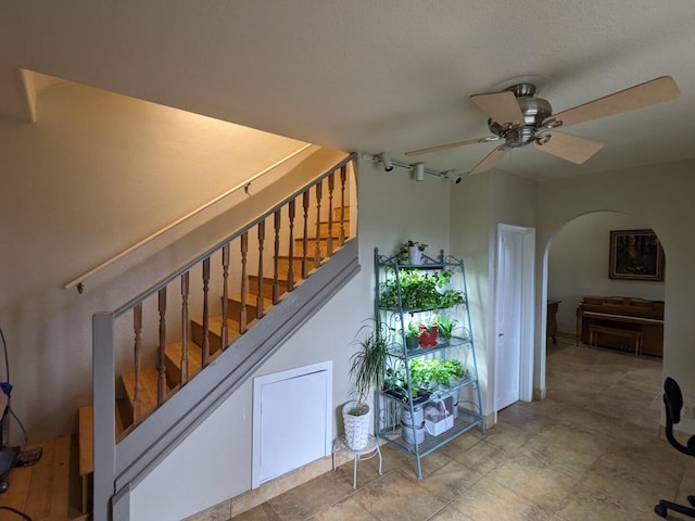 stairs featuring ceiling fan