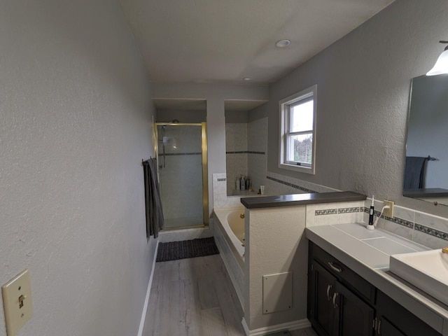 bathroom featuring wood-type flooring, independent shower and bath, and vanity