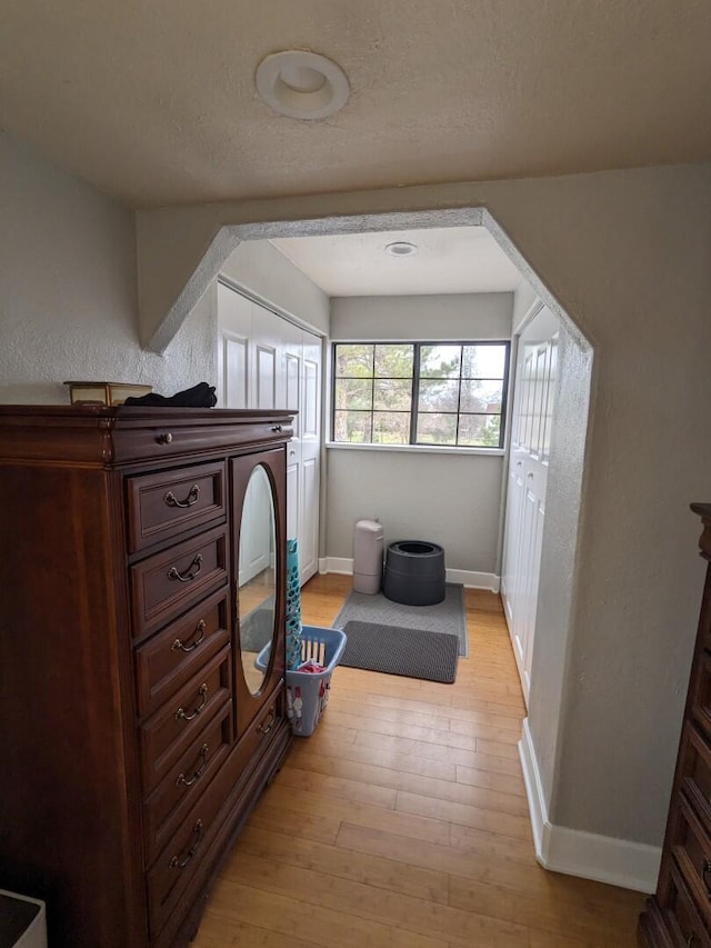 bedroom with a textured ceiling and light hardwood / wood-style floors