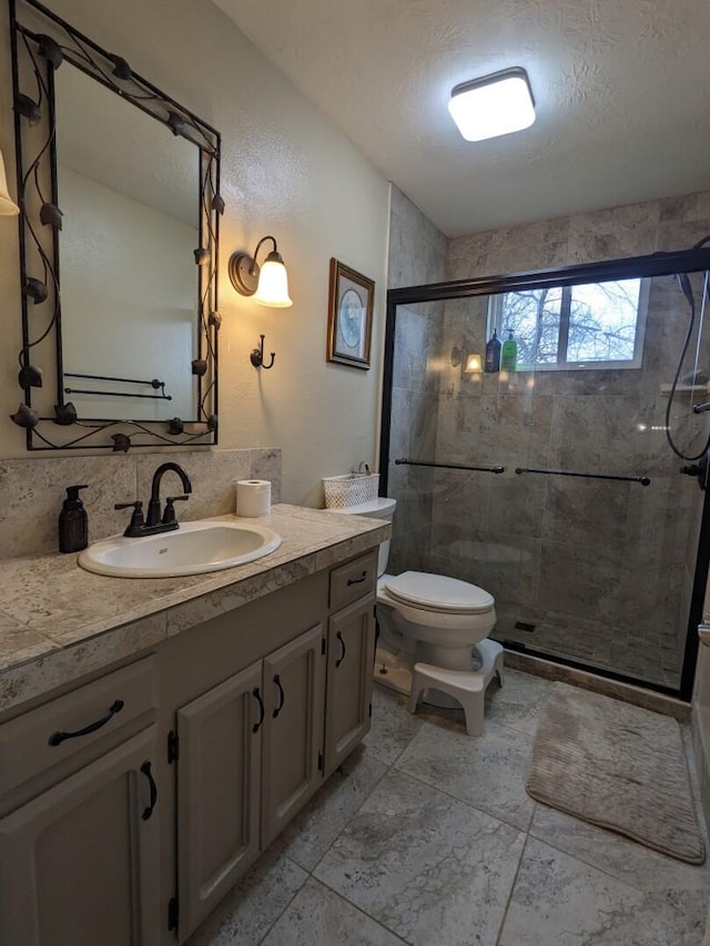 bathroom featuring toilet, walk in shower, vanity, a textured ceiling, and tasteful backsplash