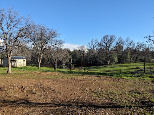 view of yard with a storage unit and a rural view