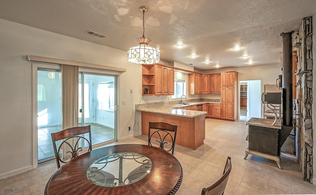 kitchen featuring kitchen peninsula, sink, a healthy amount of sunlight, and a textured ceiling