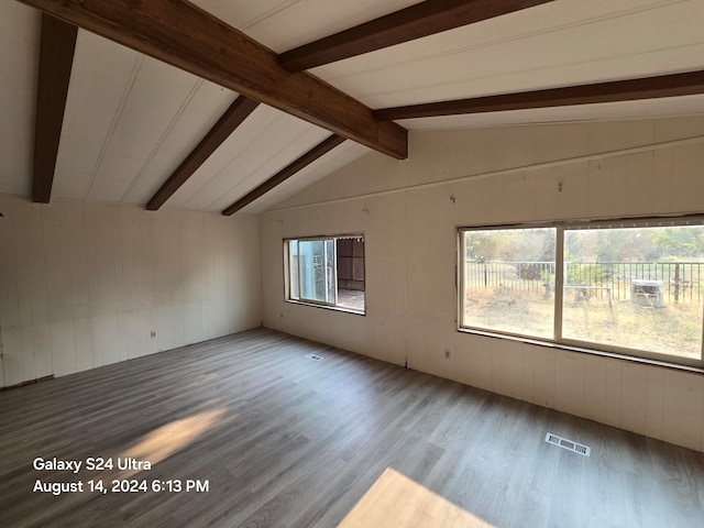 unfurnished room featuring wood-type flooring and vaulted ceiling with beams