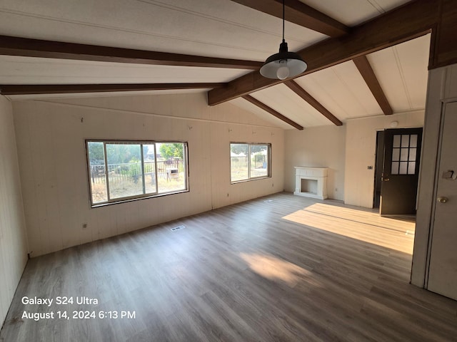 unfurnished living room featuring hardwood / wood-style flooring and vaulted ceiling with beams