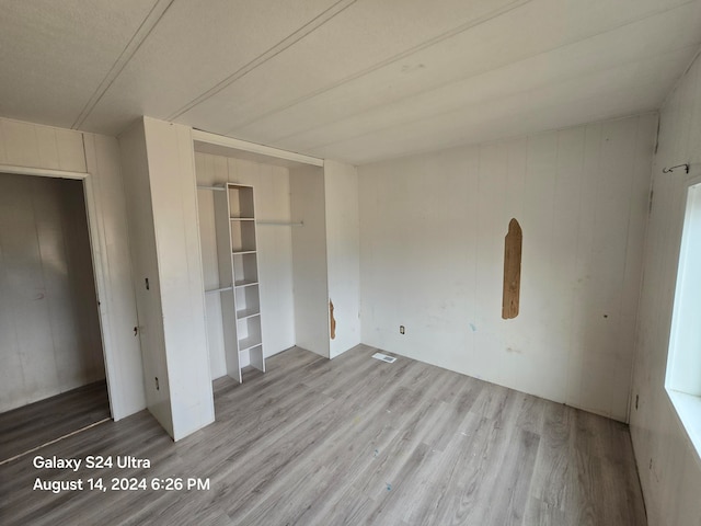 unfurnished bedroom featuring wood-type flooring and a closet