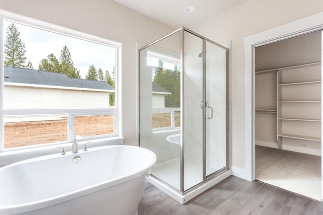 bathroom with hardwood / wood-style floors and plus walk in shower