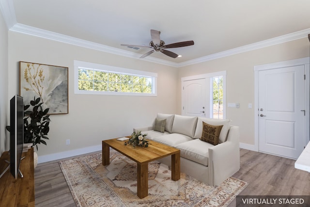 living room featuring ornamental molding, light hardwood / wood-style flooring, and plenty of natural light