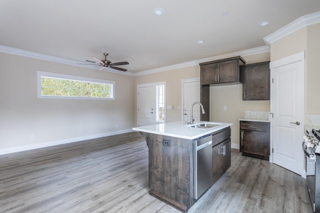 kitchen featuring light hardwood / wood-style flooring, a center island with sink, sink, crown molding, and appliances with stainless steel finishes