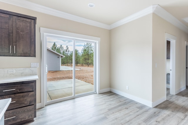 unfurnished dining area with light hardwood / wood-style floors and crown molding