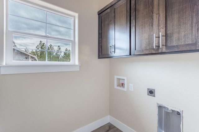 washroom featuring hookup for an electric dryer, cabinets, a wealth of natural light, and hookup for a washing machine