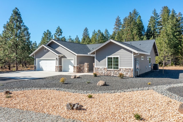 ranch-style home featuring central AC unit and a garage