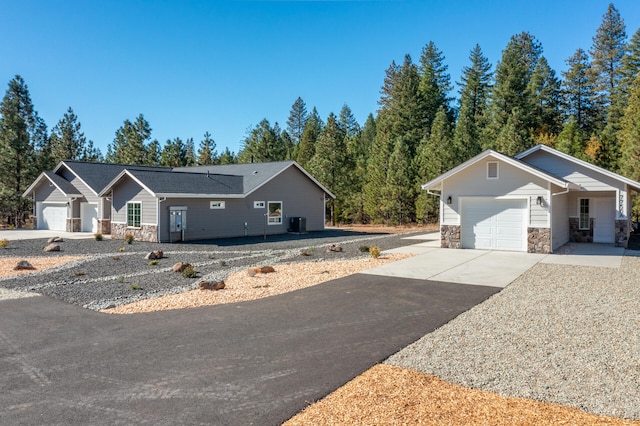 ranch-style home featuring central AC and a garage