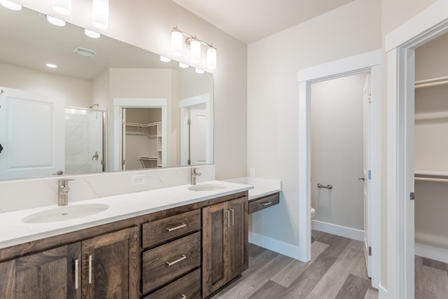 bathroom featuring hardwood / wood-style floors, double sink vanity, and toilet