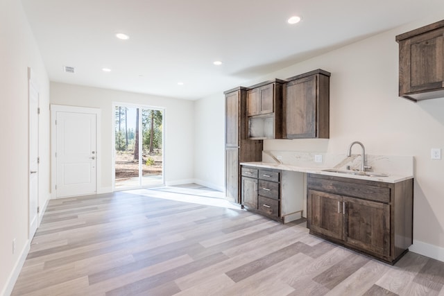 kitchen with sink, light hardwood / wood-style flooring, and dark brown cabinets