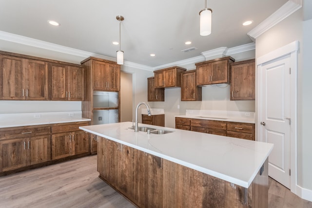 kitchen featuring light hardwood / wood-style flooring, ornamental molding, sink, and hanging light fixtures