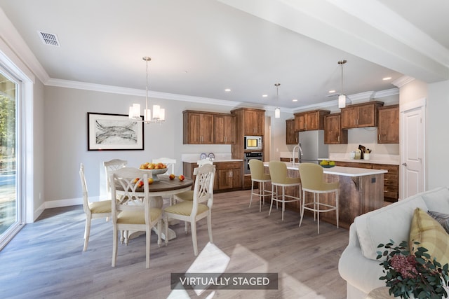 dining area with light hardwood / wood-style flooring and ornamental molding