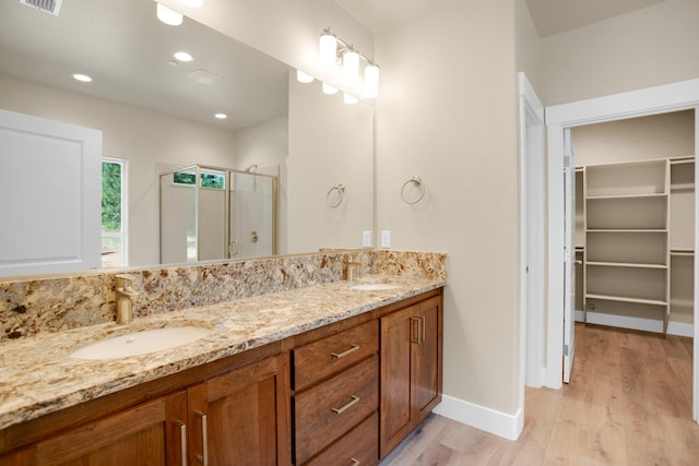 bathroom featuring a shower with door, vanity, and hardwood / wood-style floors