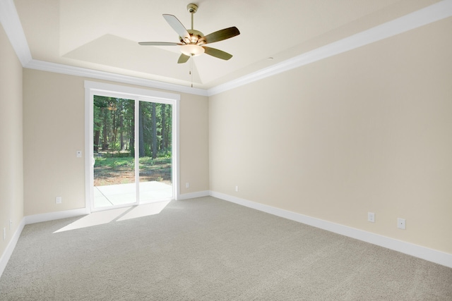 empty room featuring ceiling fan, light colored carpet, and a raised ceiling