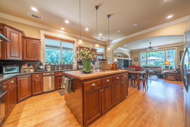 kitchen featuring light hardwood / wood-style flooring, butcher block counters, decorative backsplash, a center island, and ceiling fan