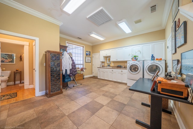 laundry room with washing machine and dryer, ornamental molding, and light tile patterned floors