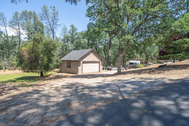 exterior space featuring a garage and an outbuilding