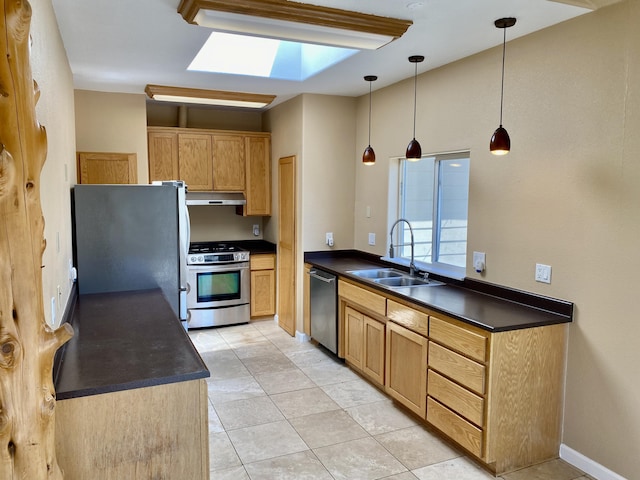 kitchen featuring a sink, dark countertops, under cabinet range hood, and stainless steel appliances