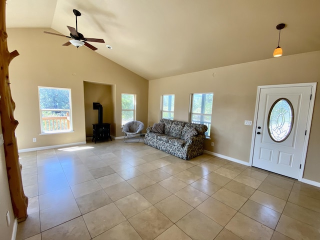 unfurnished living room featuring a wealth of natural light, a wood stove, and light tile patterned floors