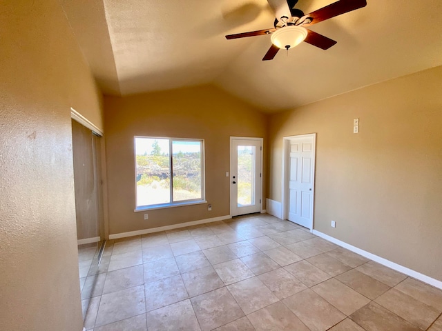 spare room with light tile patterned floors, baseboards, lofted ceiling, and a ceiling fan