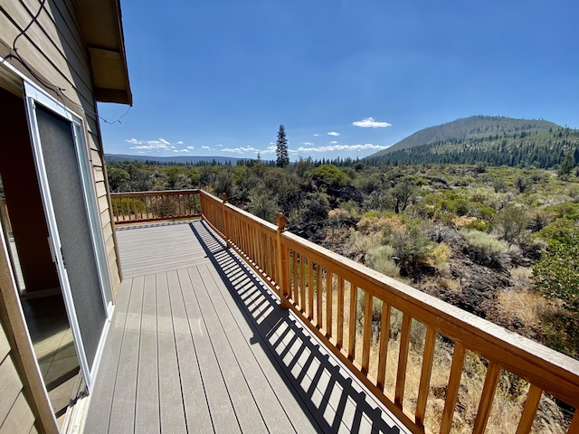 wooden terrace featuring a mountain view and a wooded view