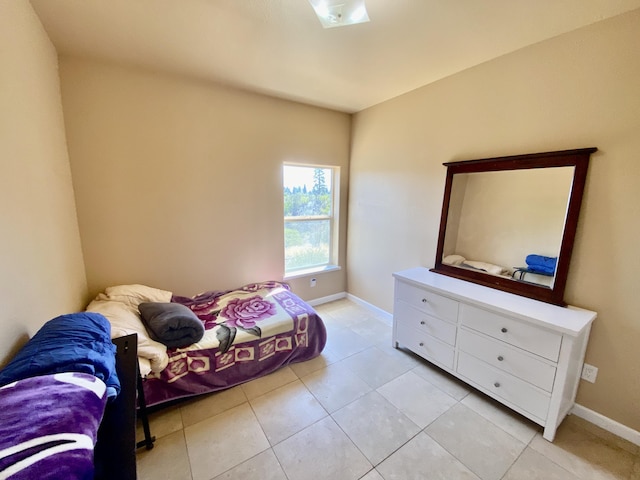 bedroom featuring light tile patterned floors and baseboards