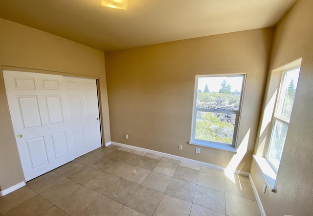 unfurnished bedroom with light tile patterned flooring and baseboards