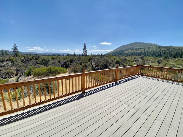 wooden terrace with a mountain view and a view of trees