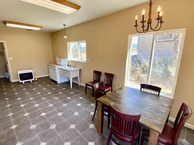 dining area with heating unit, a notable chandelier, and baseboards