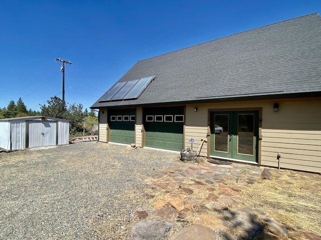 garage with french doors and a storage unit