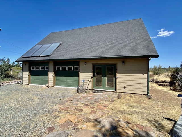 view of front of home with french doors and roof with shingles