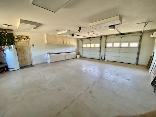 garage with gas water heater and a garage door opener