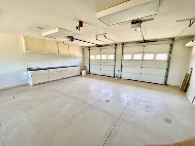 garage with baseboards and a garage door opener