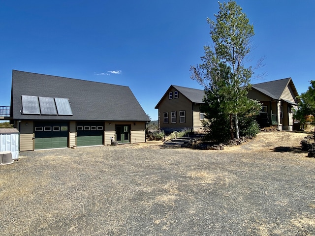 view of front of house featuring a garage and an outbuilding