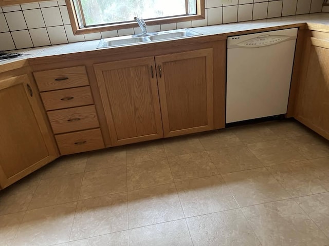 kitchen featuring dishwasher, sink, tile countertops, and tasteful backsplash