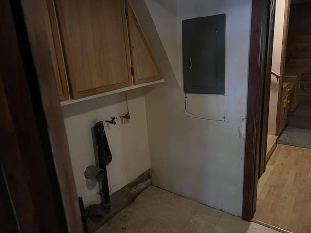 laundry room featuring electric panel and light hardwood / wood-style floors