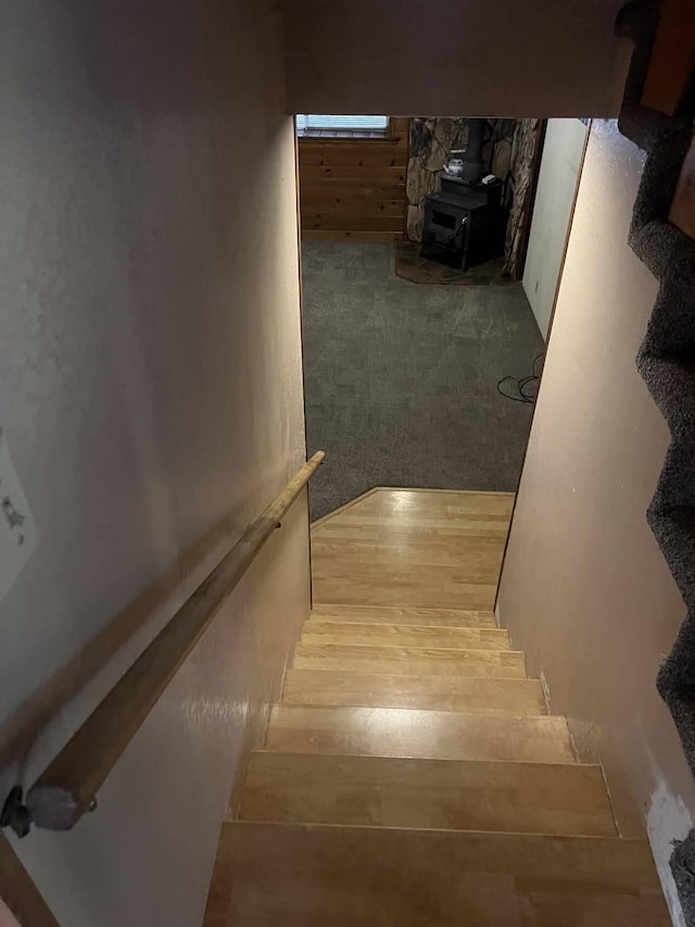 stairway featuring a wood stove and wood-type flooring