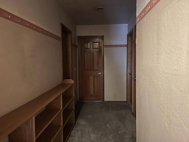 hallway with dark colored carpet