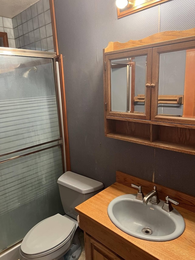 bathroom featuring vanity, toilet, and an enclosed shower