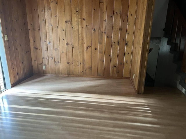 empty room with wood-type flooring and wooden walls